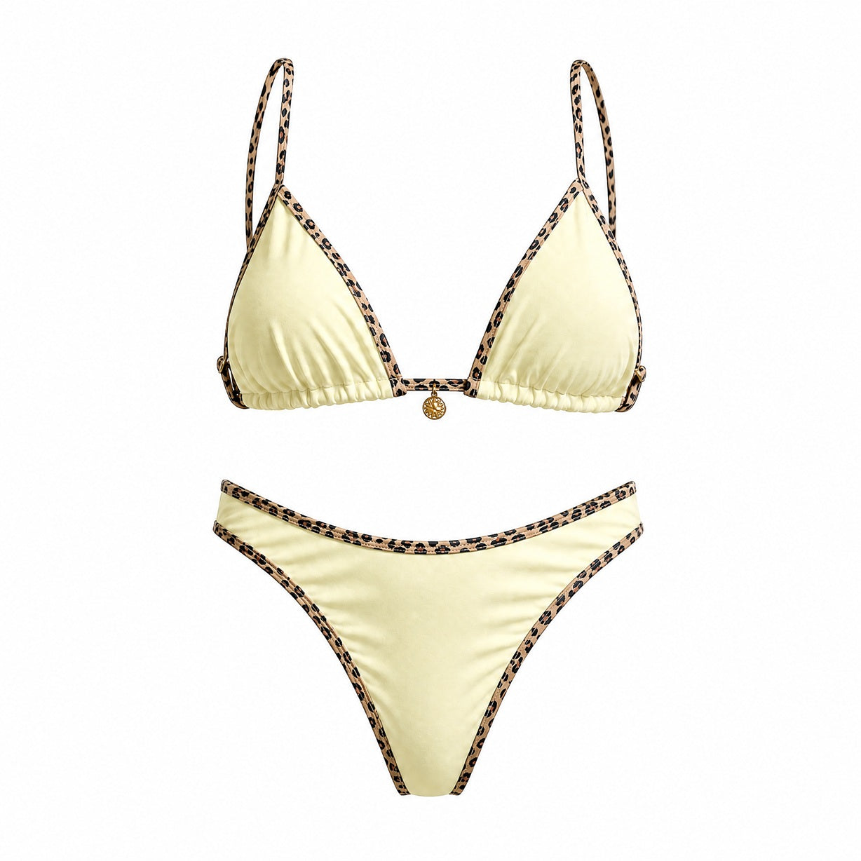 Flat lay of the Alessandra bikini set in black, white, and cream featuring leopard print contrast piping and a gold sun charm detail.