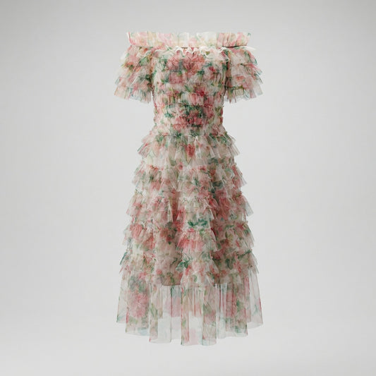 Model wearing the Amy Floral Midi Dress in light pink and green tiered tulle with an off-the-shoulder ruffled neckline.