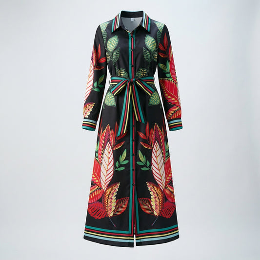 Serena long sleeve maxi shirt dress with bold red and green tropical botanical print on black fabric, featuring a striped waist belt and structured collar.