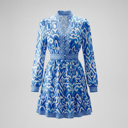 Flat lay of Wafa Blue and White Ikat print long sleeve mini dress, 90cm length, with button-down front and tiered ruffle hem