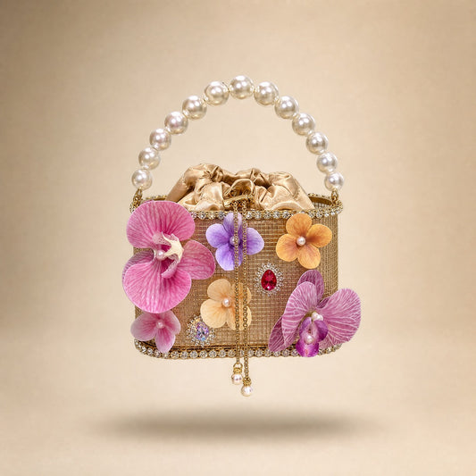 large pearl handle, pink 3D orchid flowers, gold mesh base, and hanging pearl chains Clutch Bag with a champagne satin drawstring lining, 3D floral details, and an oversized pearl top handle