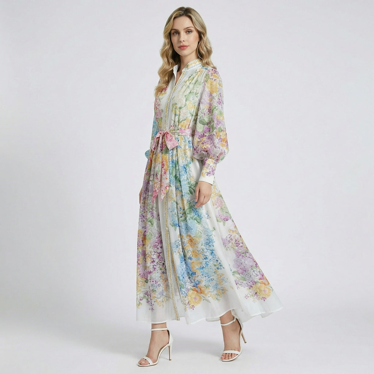 Full-length view of the Adelya floral chiffon maxi dress with vibrant pink, blue, and yellow garden patterns and a waist tie.