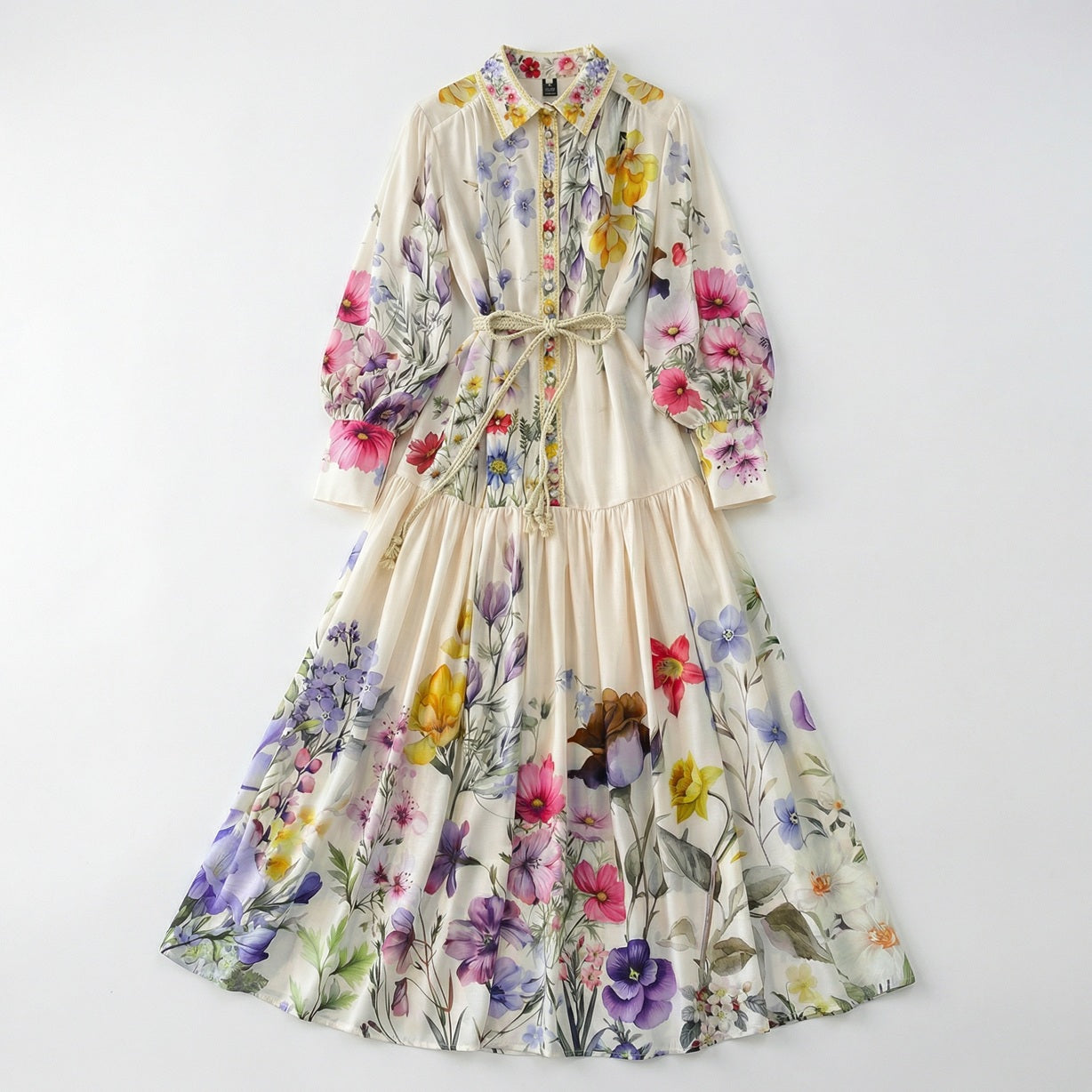 Full-length view of Adibah cream floral maxi dress with pink and purple flowers, bishop sleeves, and a braided rope belt