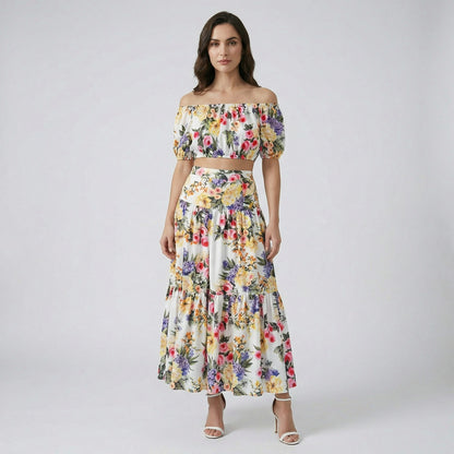The Alexandra two-piece set featuring a white floral off-the-shoulder crop top and a matching 100cm tiered maxi skirt