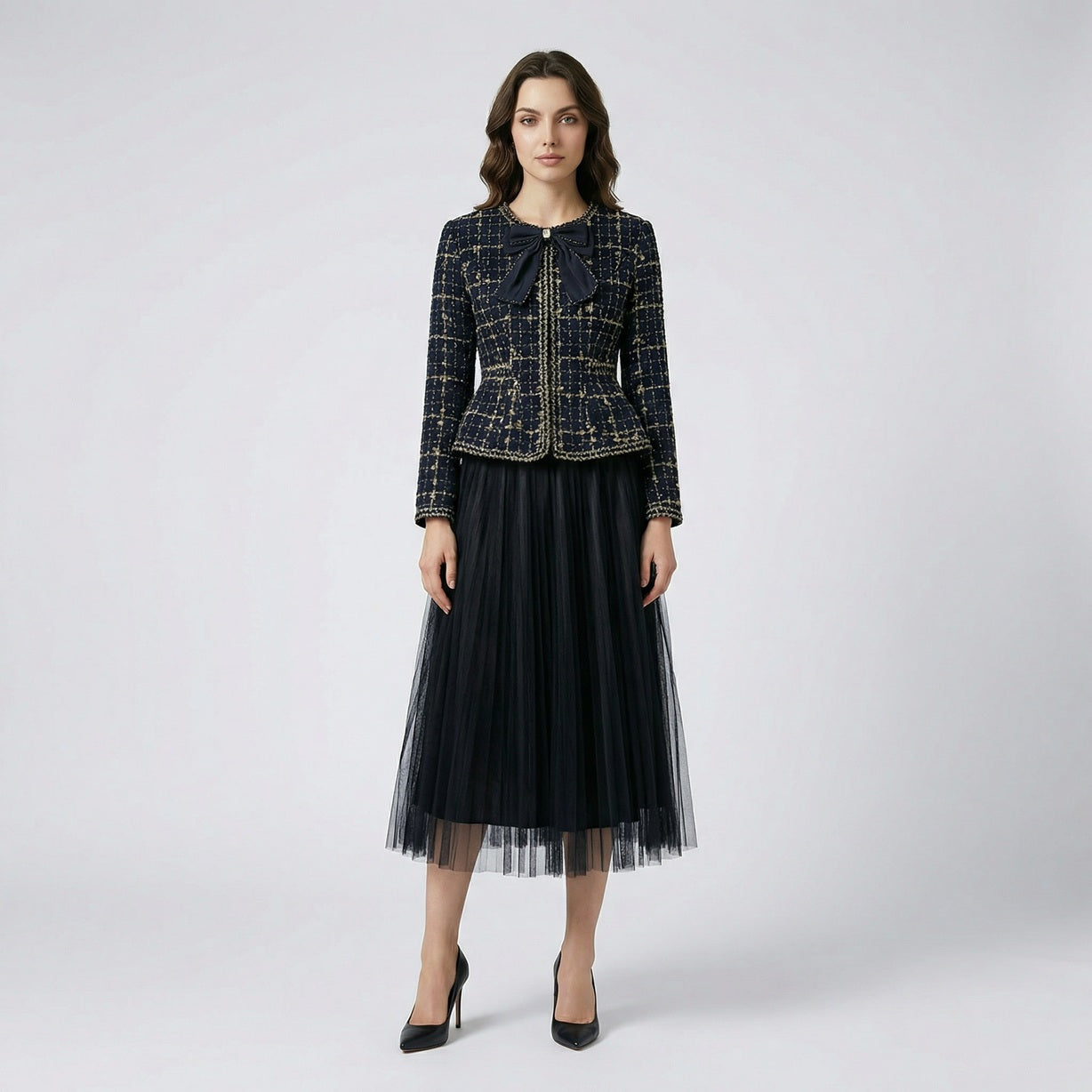 ANA two-piece set featuring a navy and gold tweed peplum jacket with a black bow and a 85cm long pleated tulle maxi skirt.