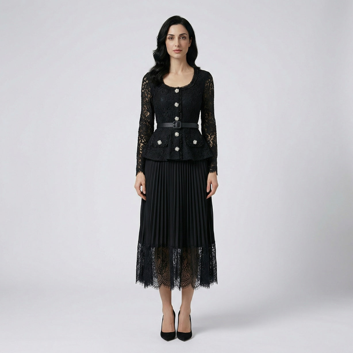 Front view of the Anitta maxi dress in black lace with pleated skirt and belt on a display background.