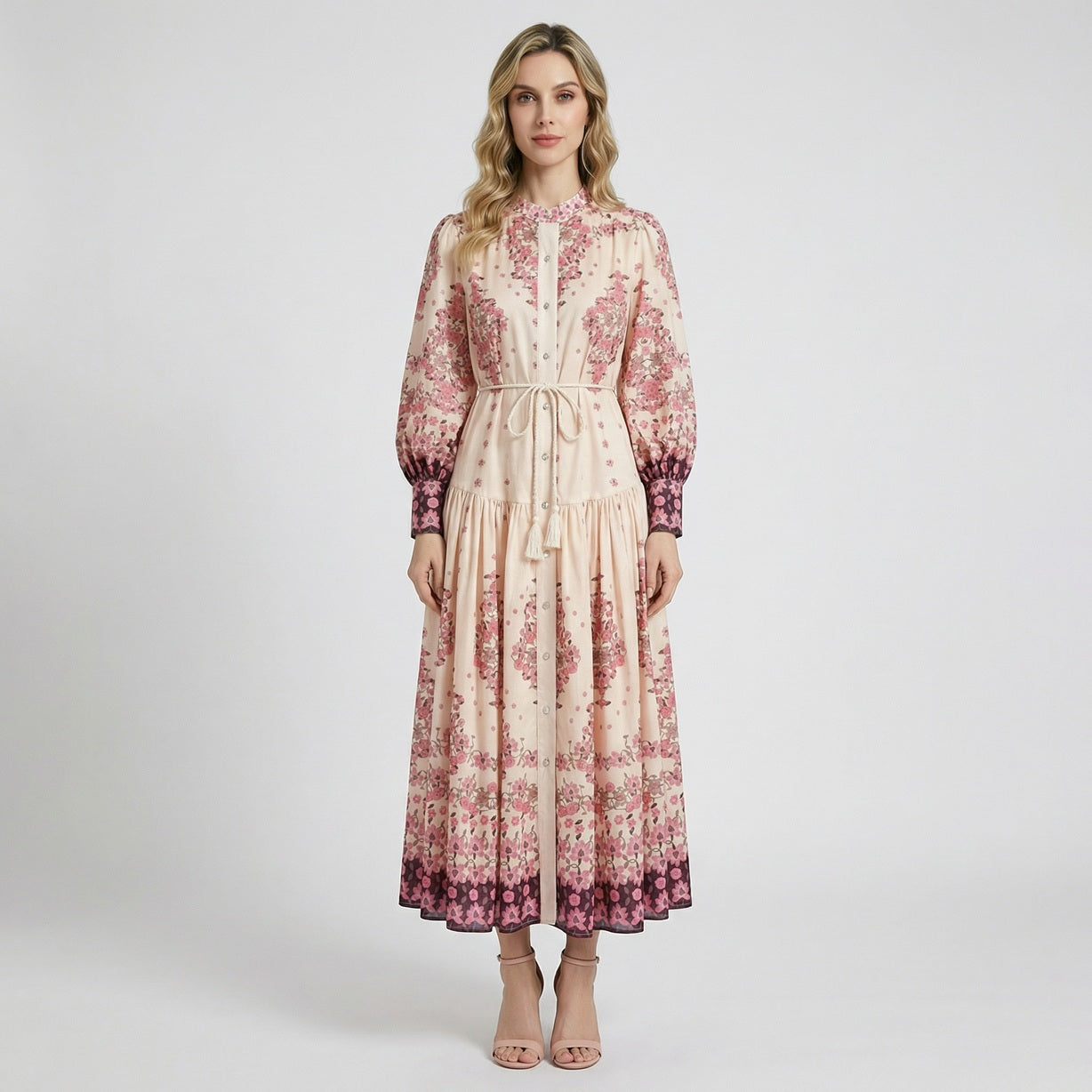 Front view of the Barbara floral maxi dress in cream and pink with puff sleeves and a braided tassel belt