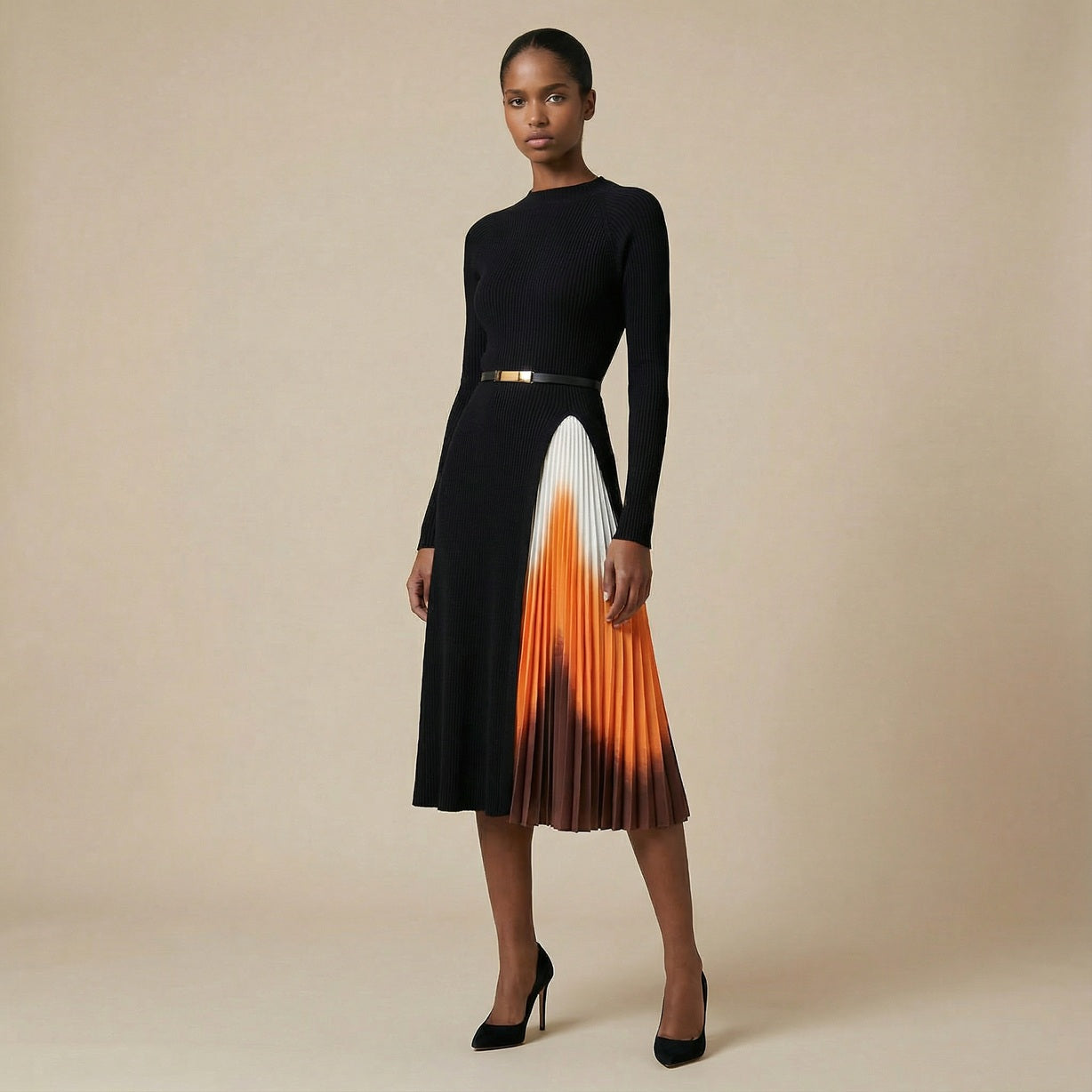 A woman wearing the Bessy black long-sleeved ribbed knit midi dress featuring a side pleated accordion skirt with a white, orange, and brown ombré design.