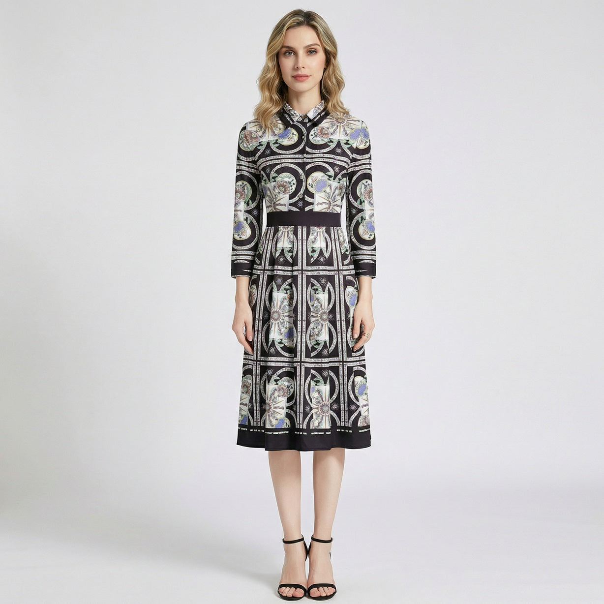 Woman wearing the Bianca black and gold ornate geometric print midi shirt dress with 3/4 sleeves and black heels.
