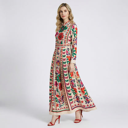 Woman wearing Candi cream maxi dress with colorful floral butterfly print and long sleeves.