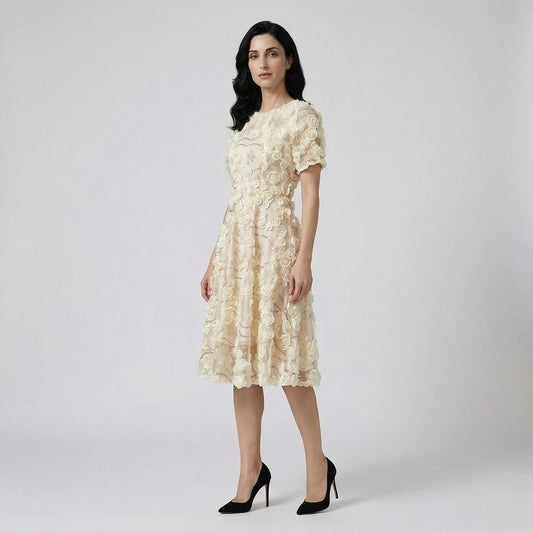 Front view of the Cindi champagne midi dress featuring white 3D fabric roses and rose gold sequin detailing on a white faux fur rug.