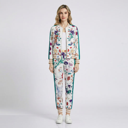 Woman wearing the Delia two-piece tracksuit featuring a floral print bomber jacket and matching joggers with teal side stripes.