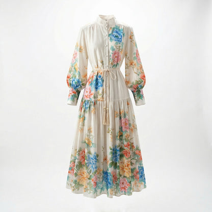 Cream-colored Fiorella maxi dress with colorful blue and pink floral print, featuring lantern sleeves and a tassel waist rope.
