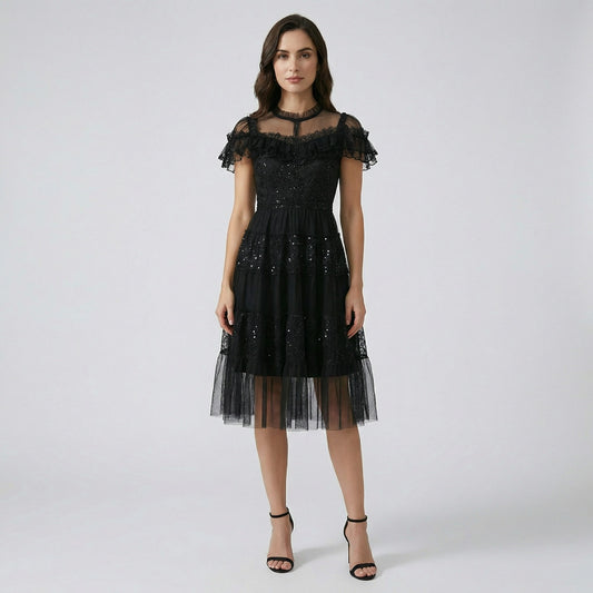 Model wearing Flavia black sequin tulle dress with tiered skirt and ruffled lace neckline.