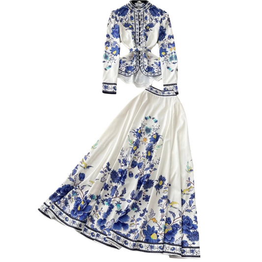 Elegant two-piece floral print set featuring a belted long sleeve blouse and a matching flowy maxi skirt available in blue, pink, and black.