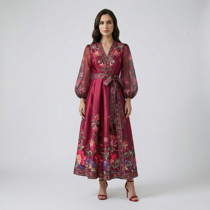 Garnet floral print maxi dress in deep wine red with sheer puff sleeves and wrap waist on a white display background.