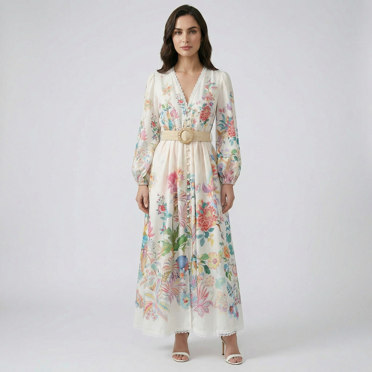 Full-length Hana floral maxi dress in cream with colorful botanical print, balloon sleeves, and woven straw belt.