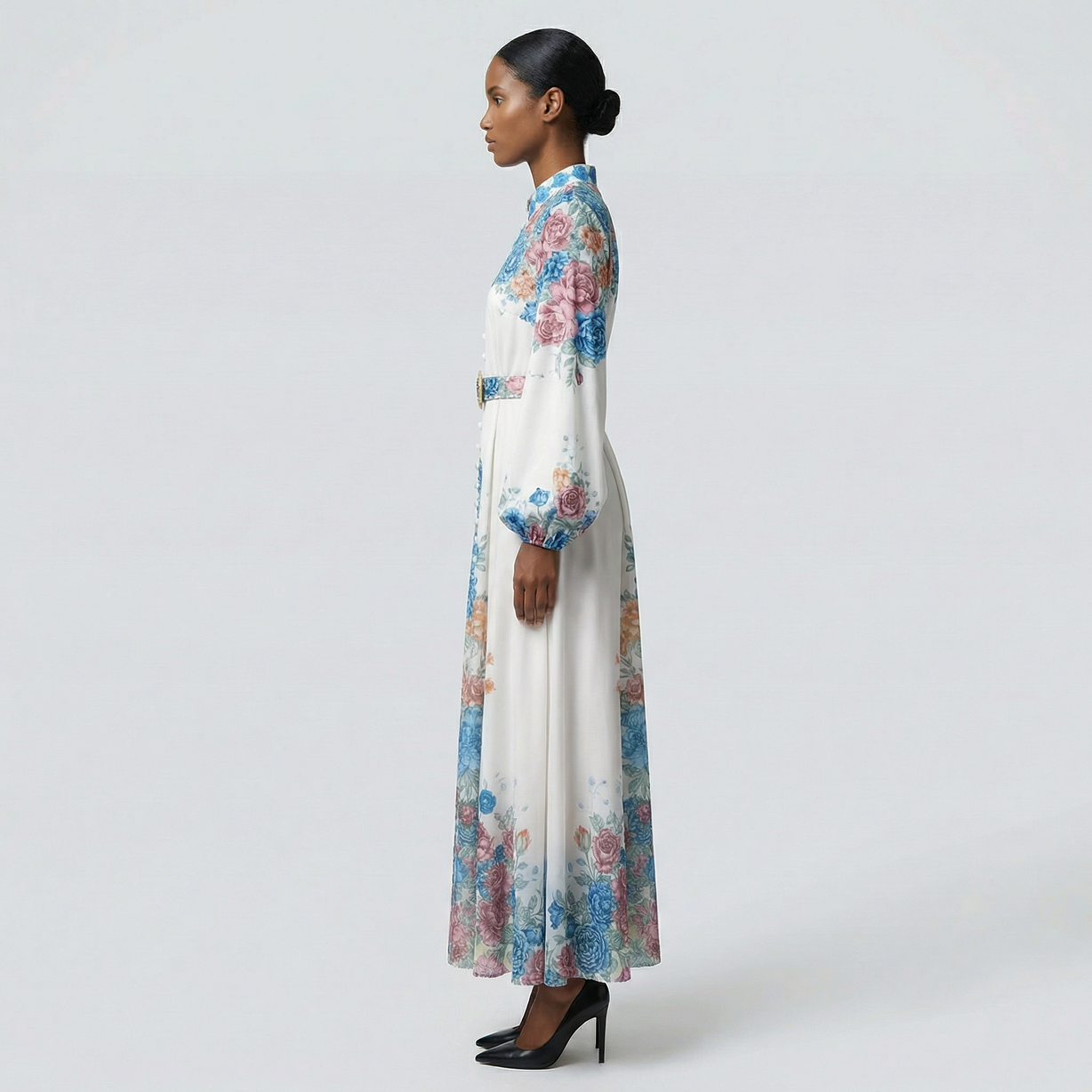 The Heba maxi dress in a 141 cm length featuring a long-sleeved ribbed knit bodice and a dramatic side-pleated accordion skirt with a matching waist belt.