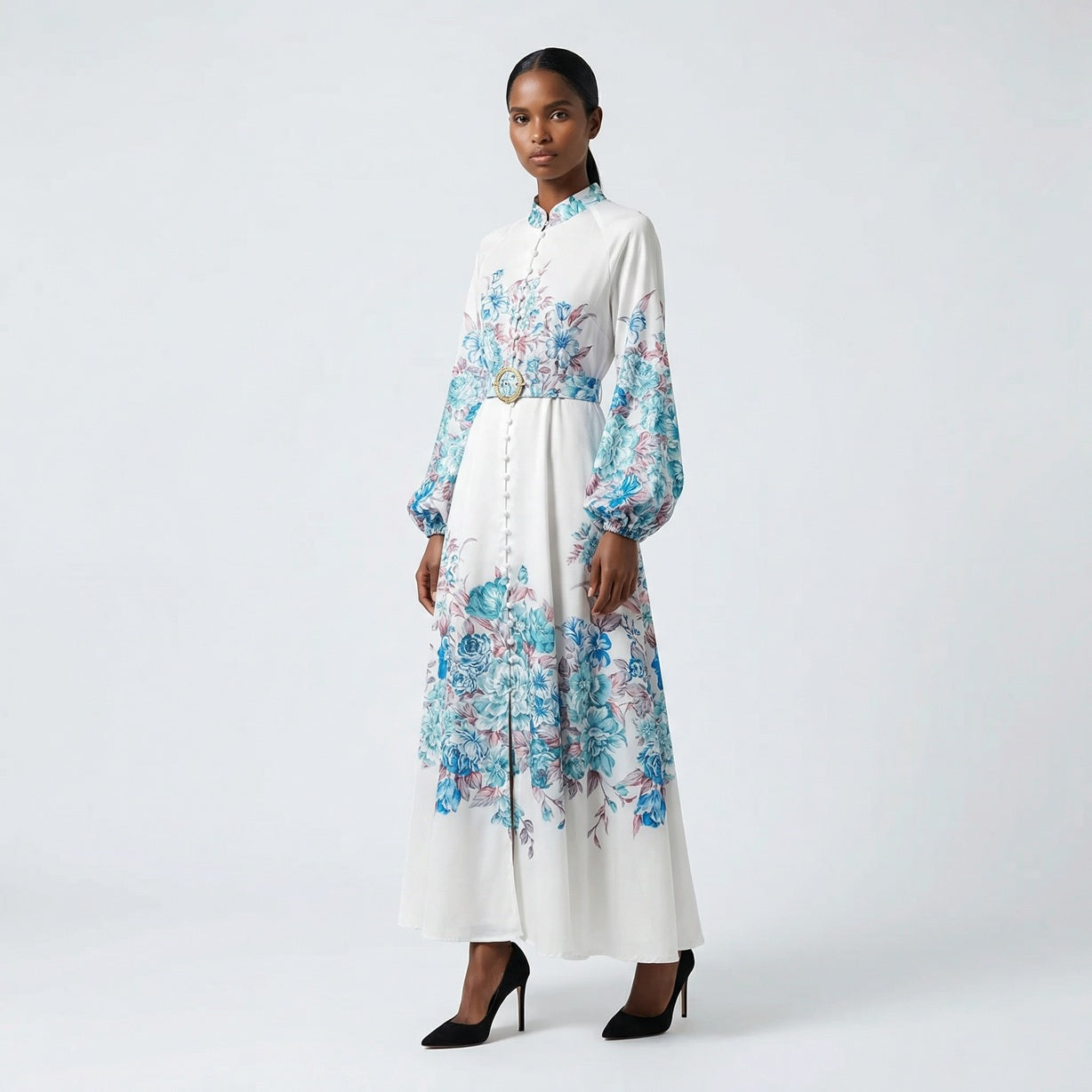 The Heba maxi dress in a 141 cm length featuring a long-sleeved ribbed knit bodice and a dramatic side-pleated accordion skirt with a matching waist belt.