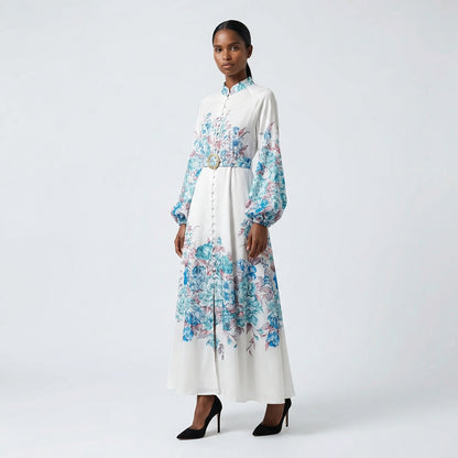 The Heba maxi dress in a 141 cm length featuring a long-sleeved ribbed knit bodice and a dramatic side-pleated accordion skirt with a matching waist belt.