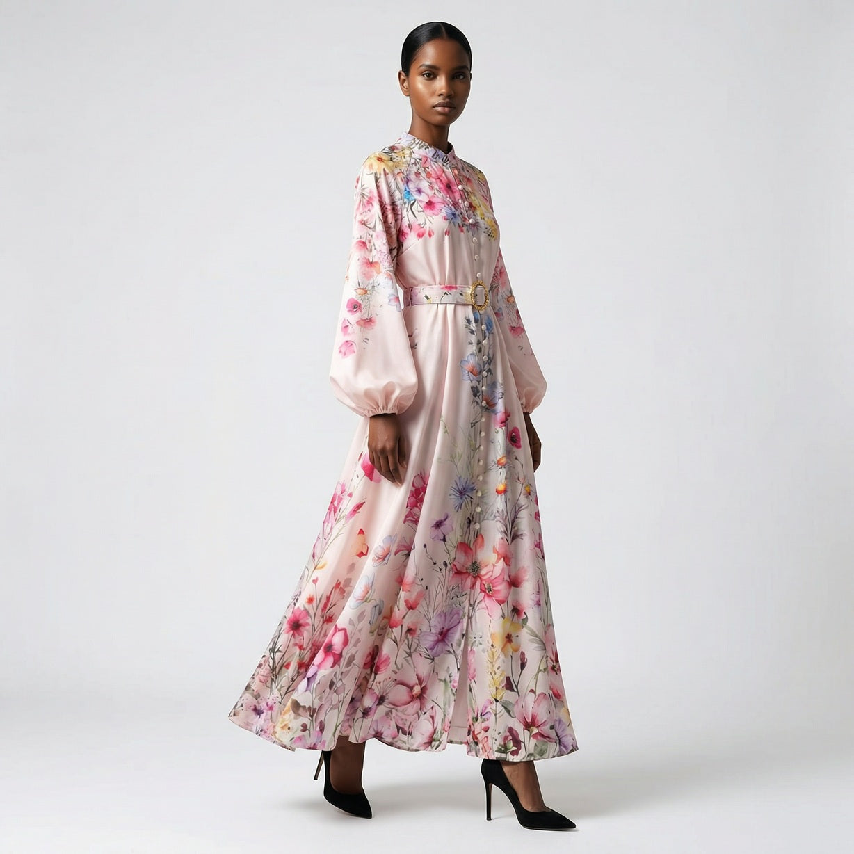 The Heba maxi dress in a 141 cm length featuring a long-sleeved ribbed knit bodice and a dramatic side-pleated accordion skirt with a matching waist belt.