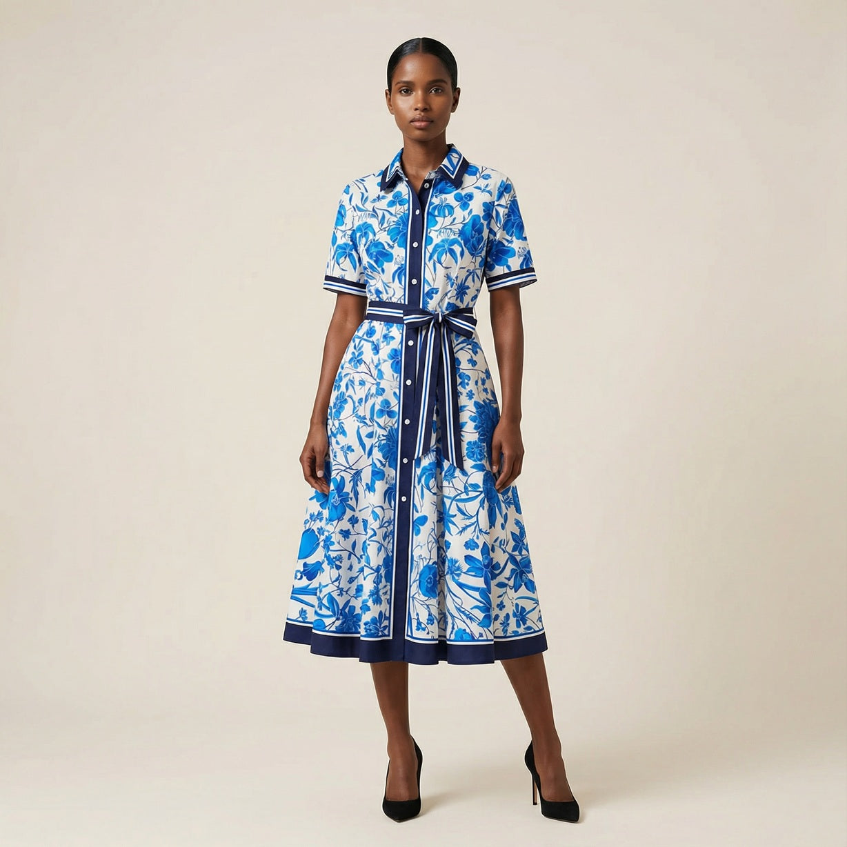 he Inese midi dress in a vibrant blue and red colorway, featuring a long-sleeved ribbed knit bodice and a side-pleated accordion skirt with a matching waist belt.