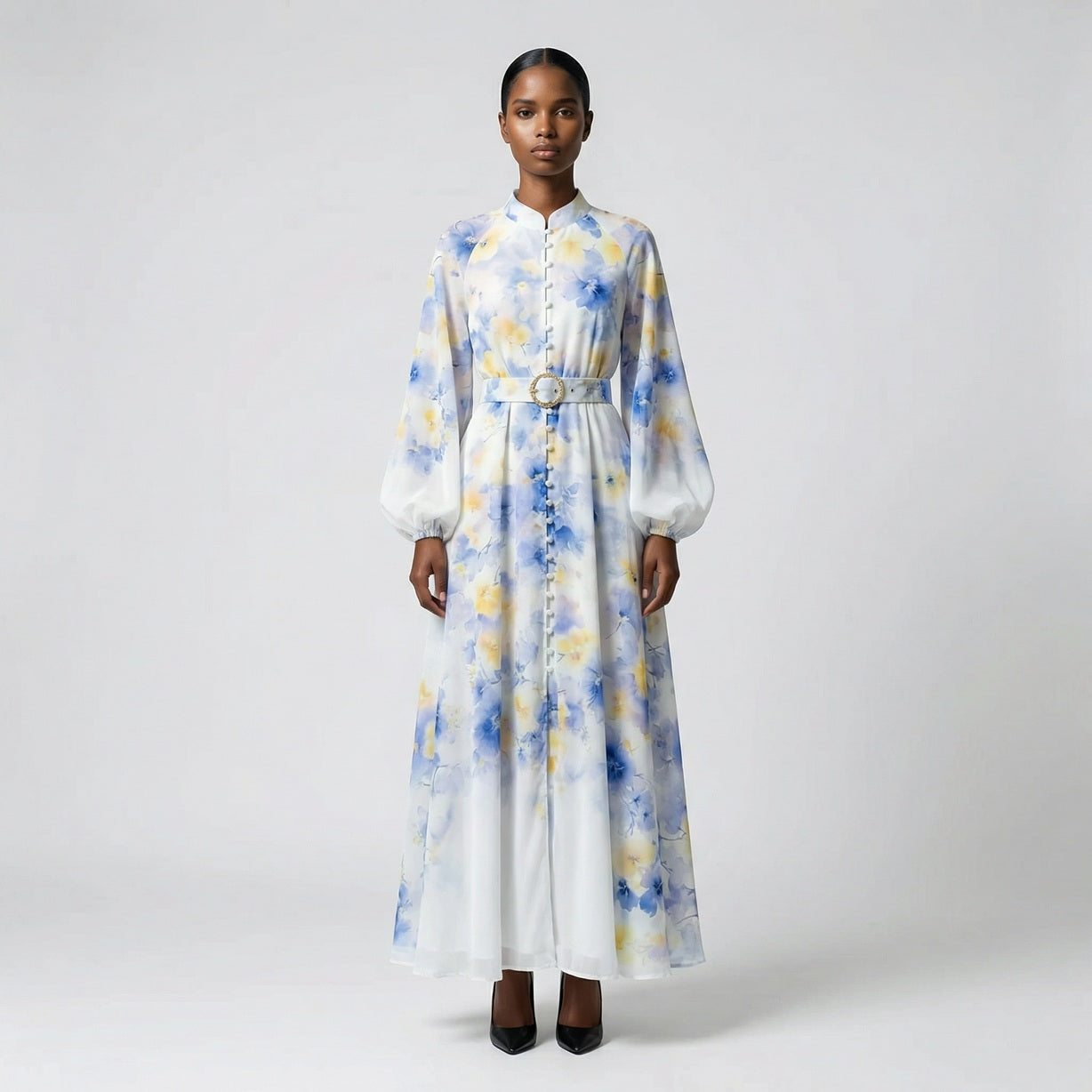 The Jana maxi dress in a 147 cm length featuring a long-sleeved ribbed knit bodice and a dramatic side-pleated accordion skirt with a matching waist belt.