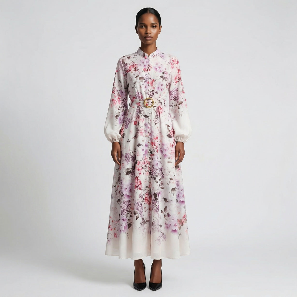 The Jana maxi dress in a 147 cm length featuring a long-sleeved ribbed knit bodice and a dramatic side-pleated accordion skirt with a matching waist belt.