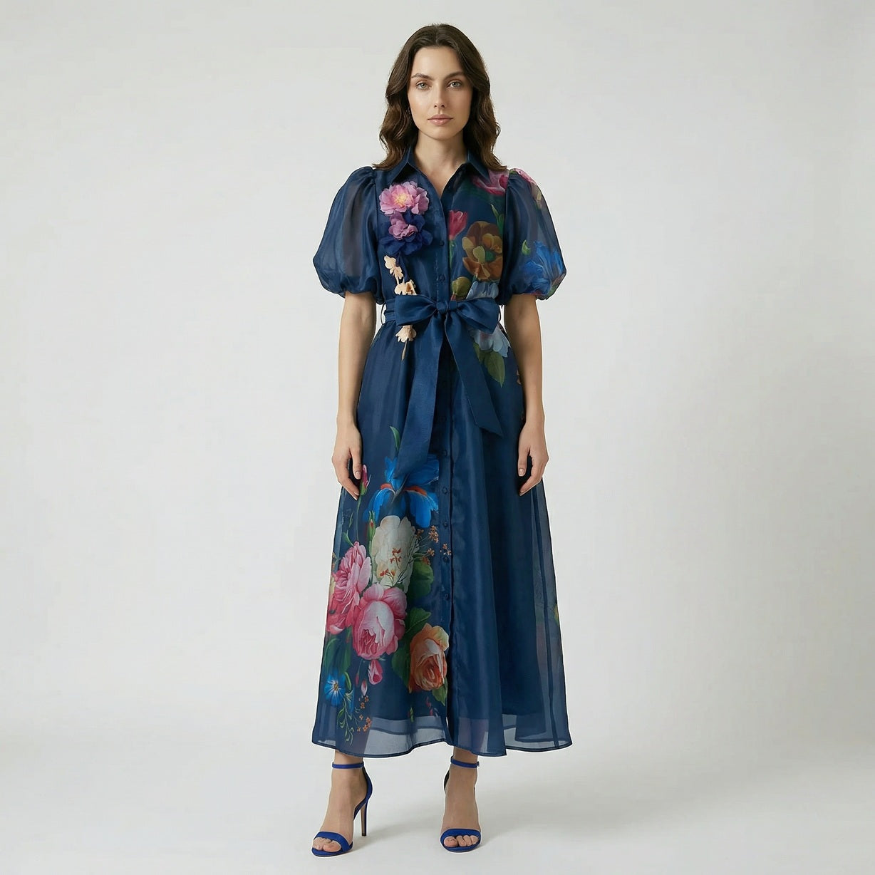 Long floral puff sleeve maxi dress with 3D flower appliqués and ribbon waist tie in pink, white, and navy blue.