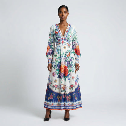 Front view of the Julie maxi dress in white featuring colorful floral and butterfly prints with a button-down front and V-neckline.