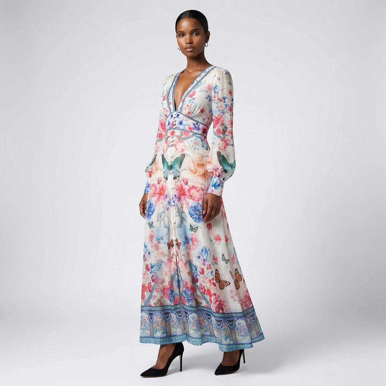 Front view of the Julie maxi dress in white featuring colorful floral and butterfly prints with a button-down front and V-neckline.
