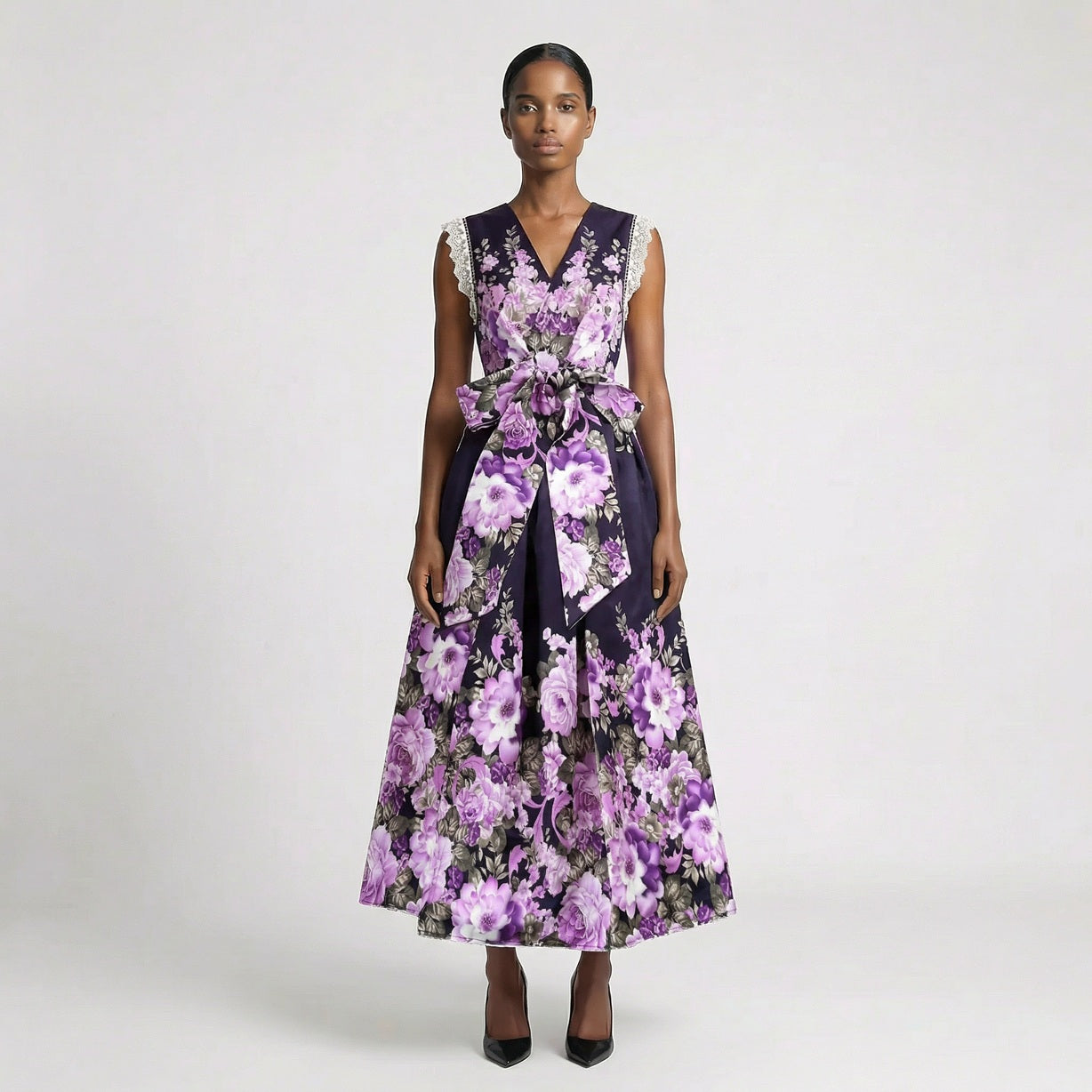 Lorelai floral print maxi dress in cream and purple featuring a v-neckline and large waist bow. Lorelai floral print maxi dress in black and purple with lace sleeve detailing and a full-length skirt.