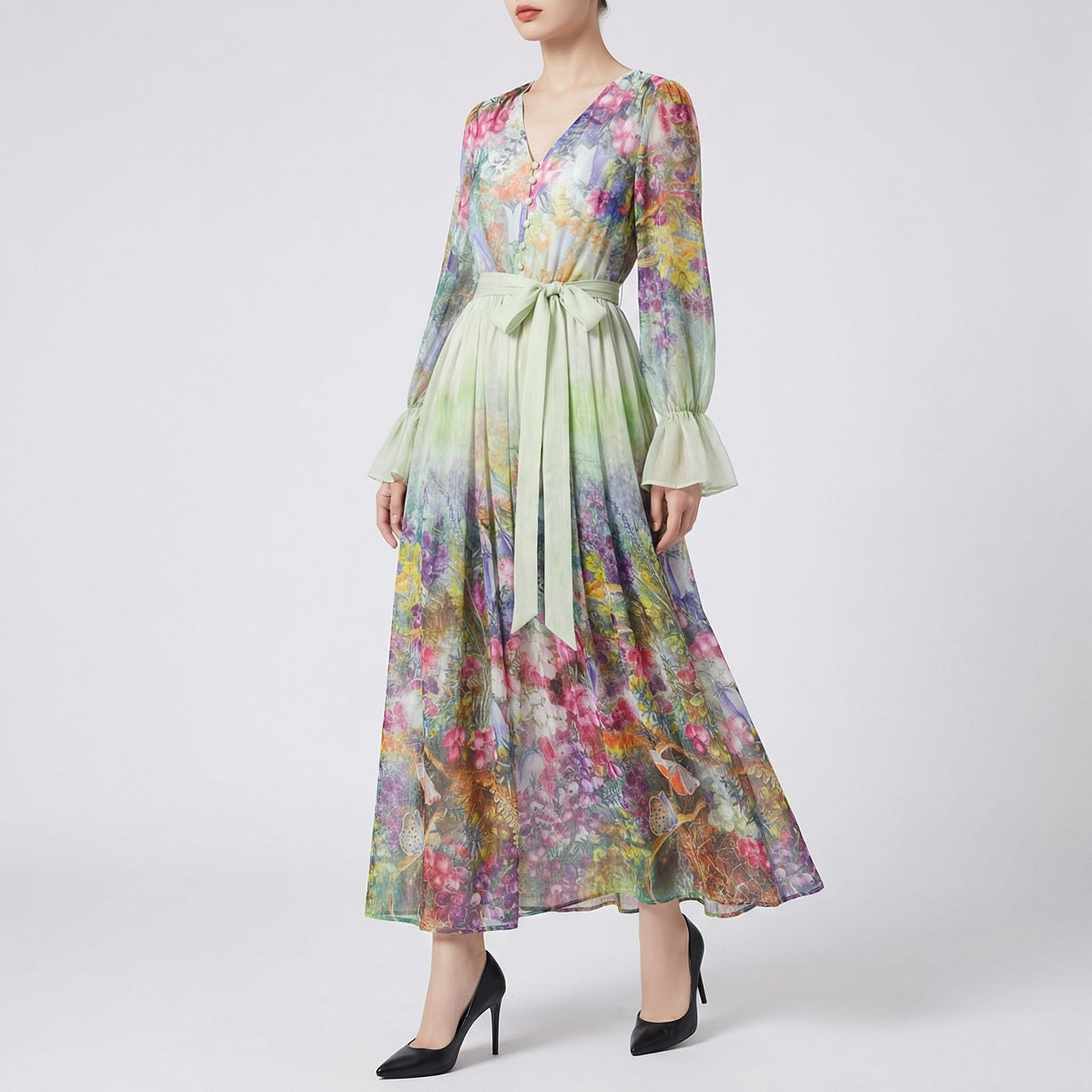 A two-piece set featuring a long-sleeved ruffle blouse and a 100cm matching botanical floral maxi skirt in sage green with a wide waist belt.