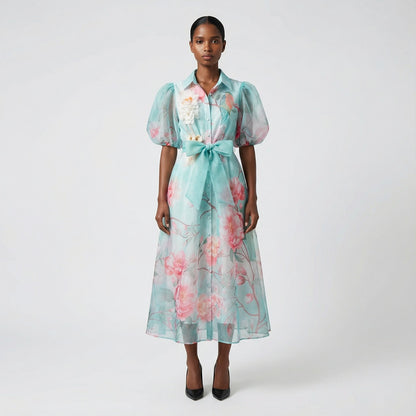 The Marie maxi dress in a 145 cm length featuring a long-sleeved ribbed knit bodice and a dramatic side-pleated accordion skirt with a matching waist belt.