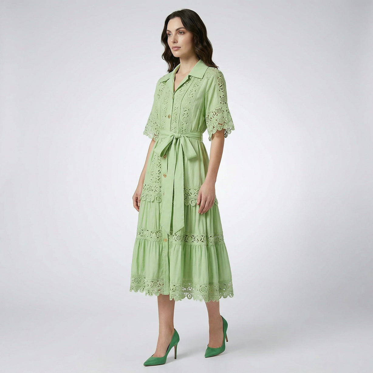 The Noora midi dress shown in black, white, sage green, and camel featuring intricate lace panels, gold buttons, and a matching belt.