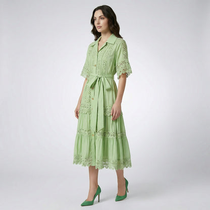 The Noora midi dress shown in black, white, sage green, and camel featuring intricate lace panels, gold buttons, and a matching belt.