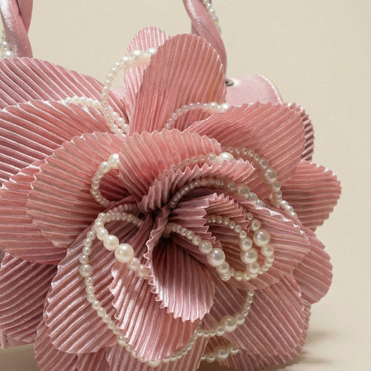 Close-up of pink clutch showing large flower and cream pearl details