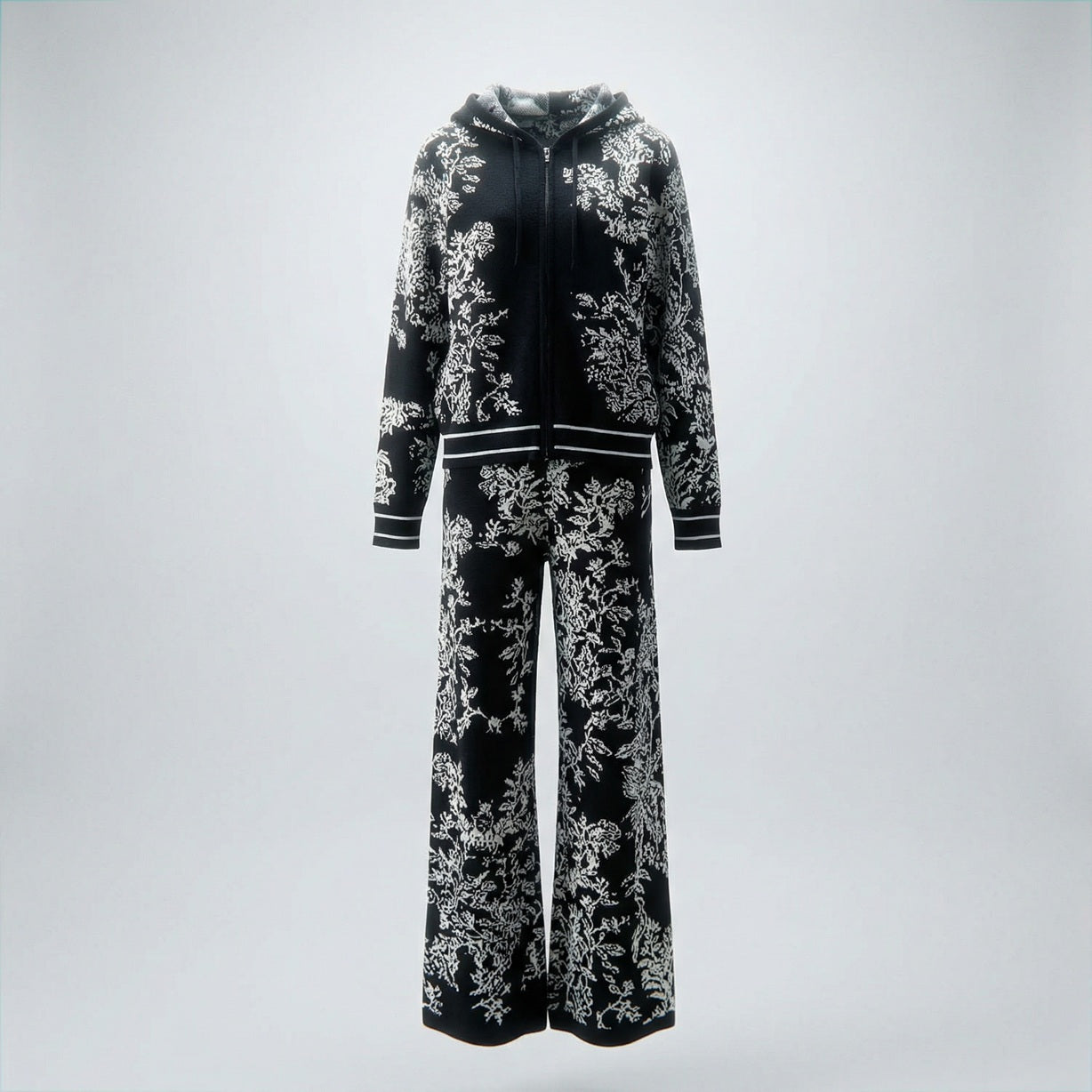 Rafaella two-piece knit tracksuit featuring a black floral jacquard pattern on a grey, cream, black, and beige background.