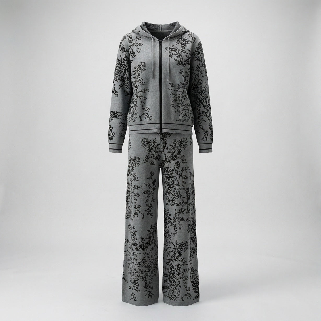 Rafaella two-piece knit tracksuit featuring a black floral jacquard pattern on a grey, cream, black, and beige background.