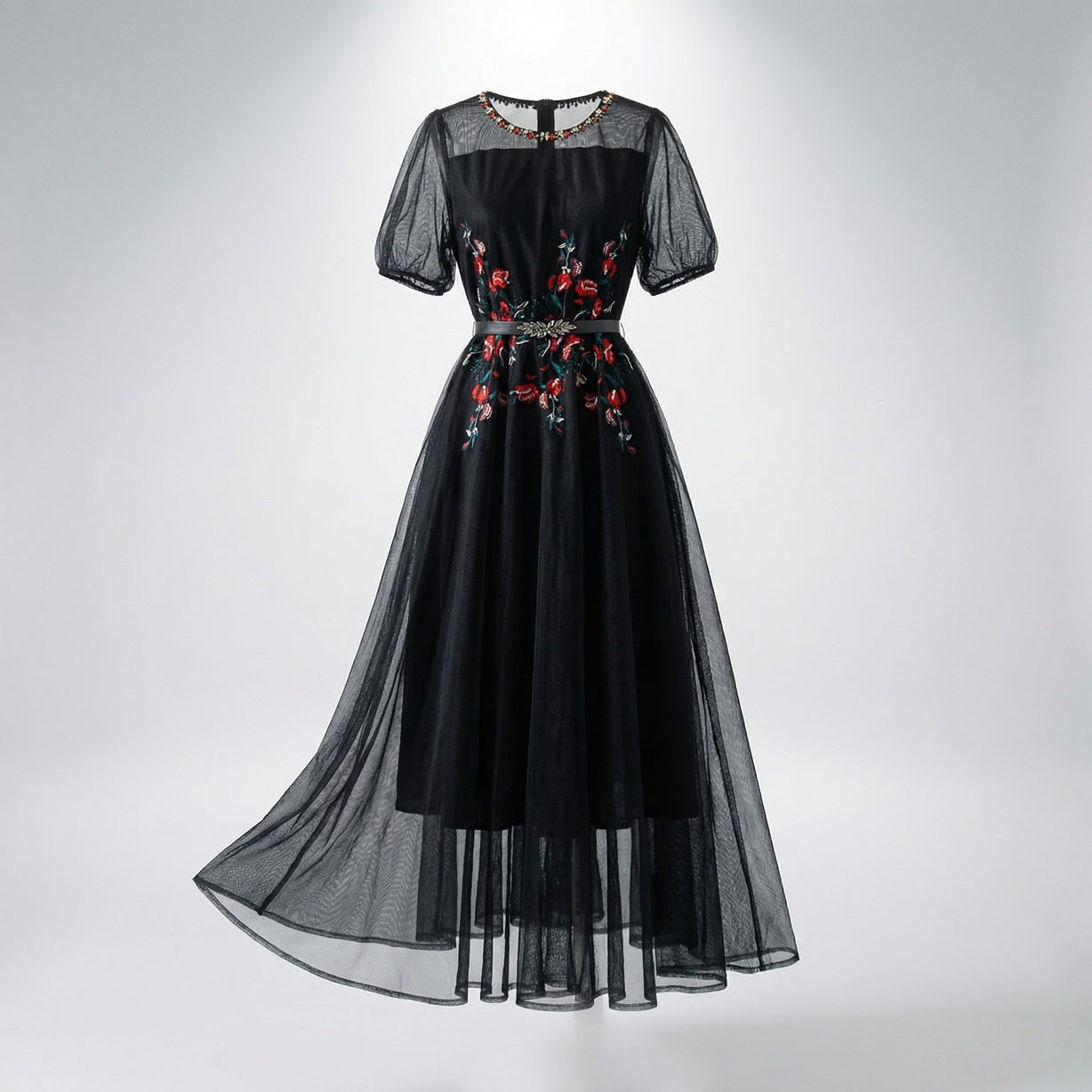 Front view of Sara midi-maxi dress in black and white featuring red floral embroidery, mesh sleeves, and a silver leaf belt