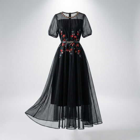 Front view of Sara midi-maxi dress in black and white featuring red floral embroidery, mesh sleeves, and a silver leaf belt
