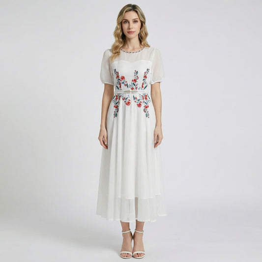 Front view of Sara midi-maxi dress in black and white featuring red floral embroidery, mesh sleeves, and a silver leaf belt