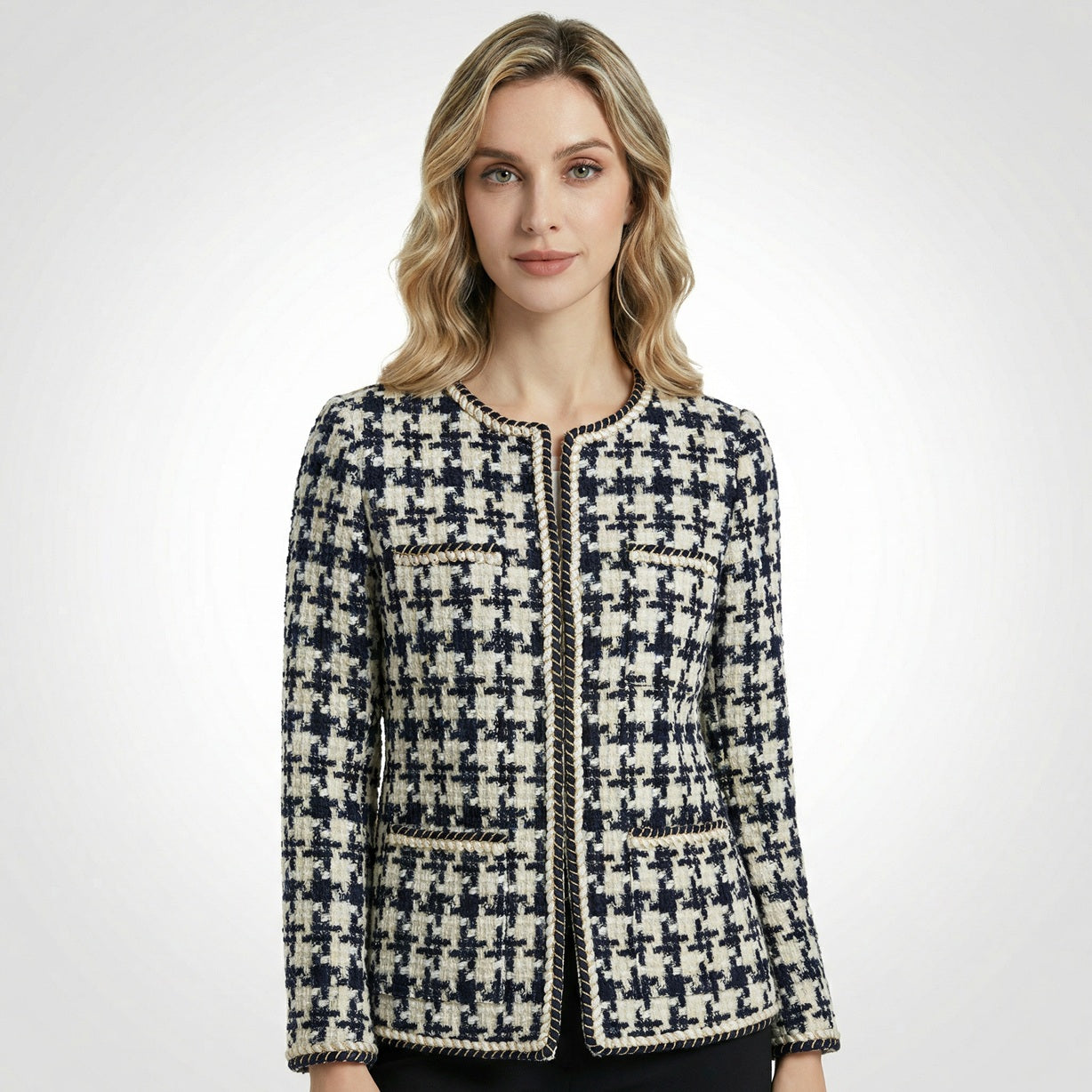 Close-up of Selina navy and cream houndstooth tweed jacket featuring gold braided trim and four front pockets.