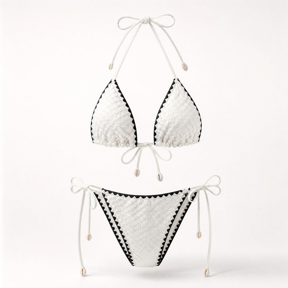 Crisp white popcorn fabric bikini with black contrast trim and shell charms.