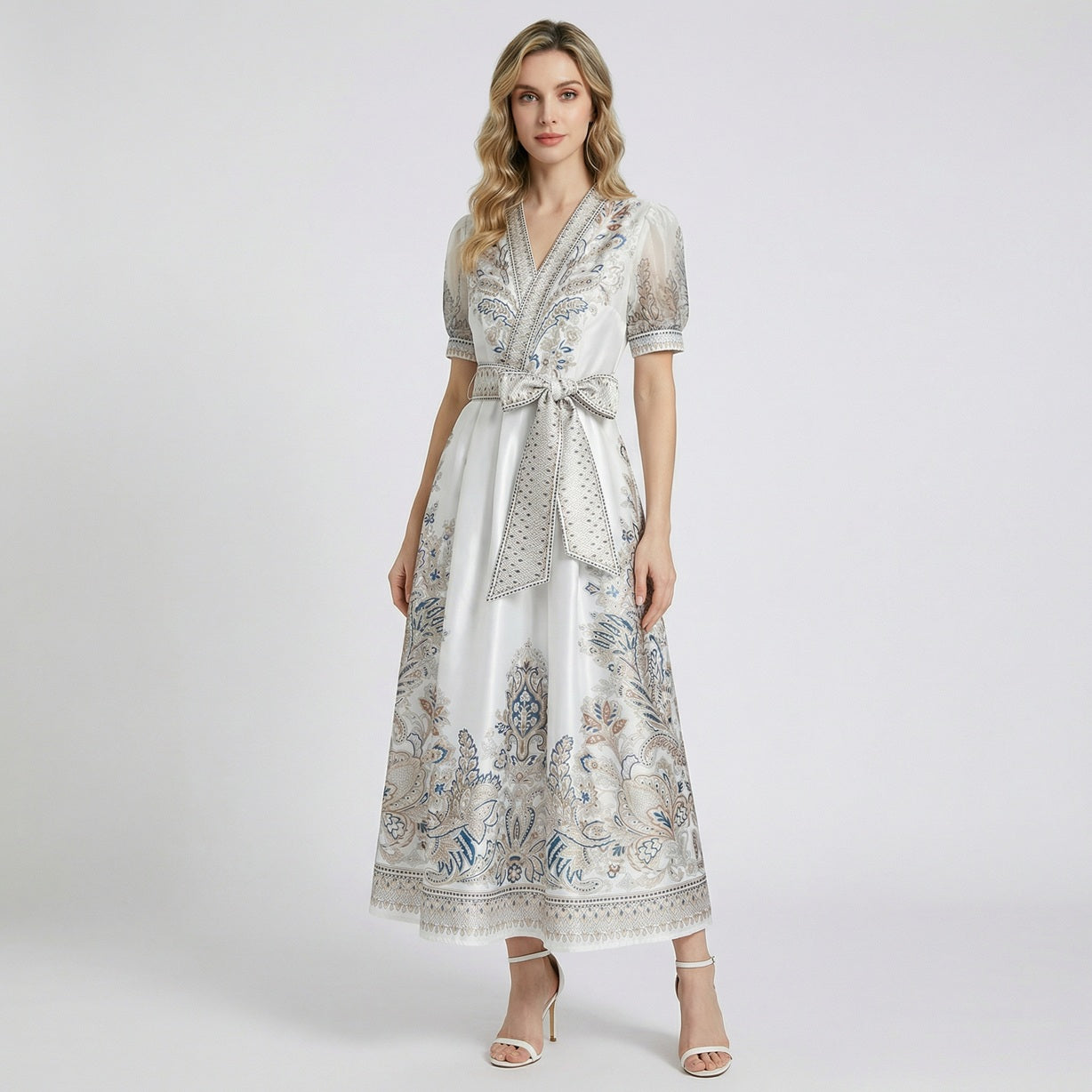 Two Teodora maxi dresses in black and white featuring paisley prints, puff sleeves, and large bow belts.