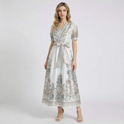 Two Teodora maxi dresses in black and white featuring paisley prints, puff sleeves, and large bow belts.