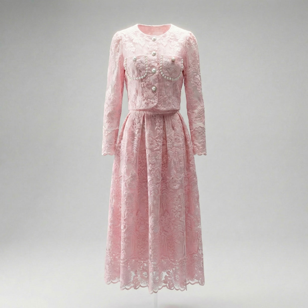 Thelma two-piece set featuring a pink floral lace cropped jacket with large pearl buttons and a matching 75cm midi skirt.