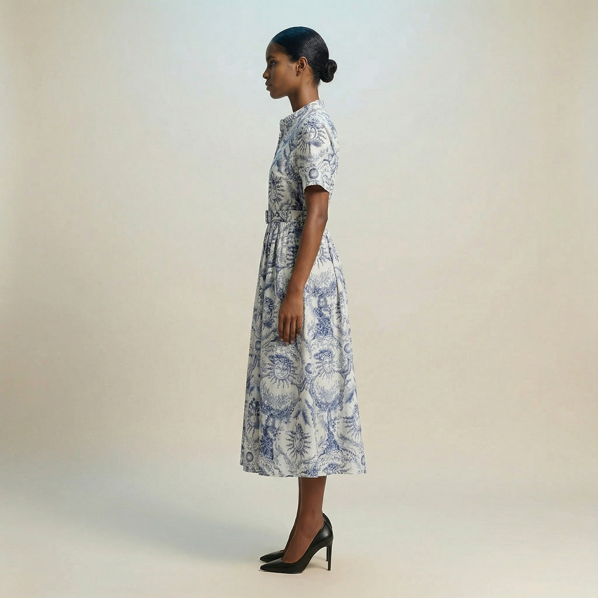 The Veronica midi dress featuring a short-sleeved ribbed knit bodice and a side-pleated accordion skirt with a matching waist belt.