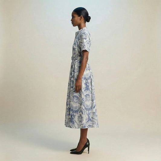 The Veronica midi dress featuring a short-sleeved ribbed knit bodice and a side-pleated accordion skirt with a matching waist belt.