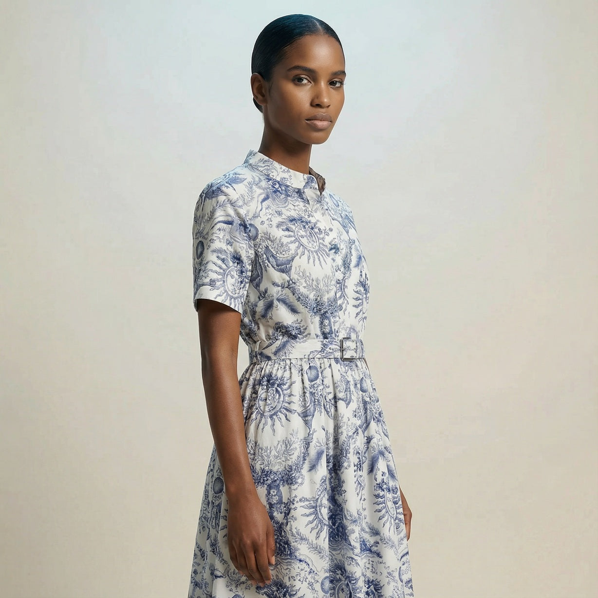 The Veronica midi dress featuring a short-sleeved ribbed knit bodice and a side-pleated accordion skirt with a matching waist belt.